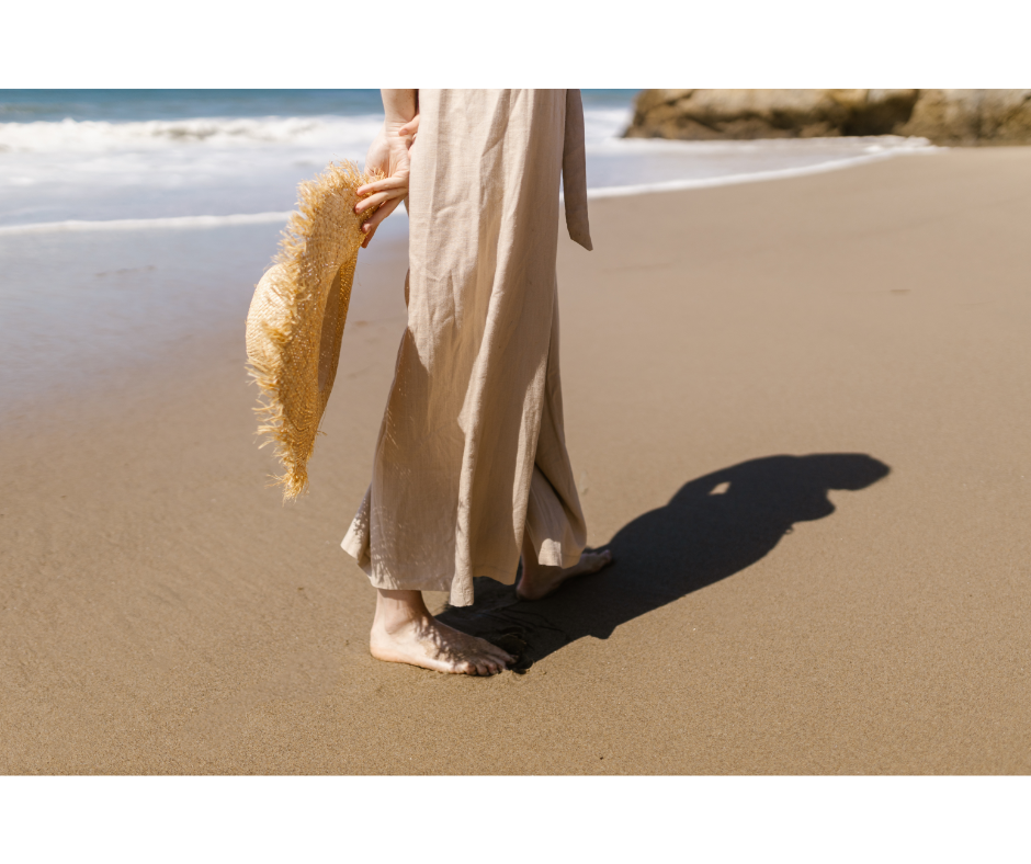 Quais saídas de praia não podem faltar no guarda-roupa de uma mulher? | Foto de uma mulher na praia com vestido longo | Água Doce